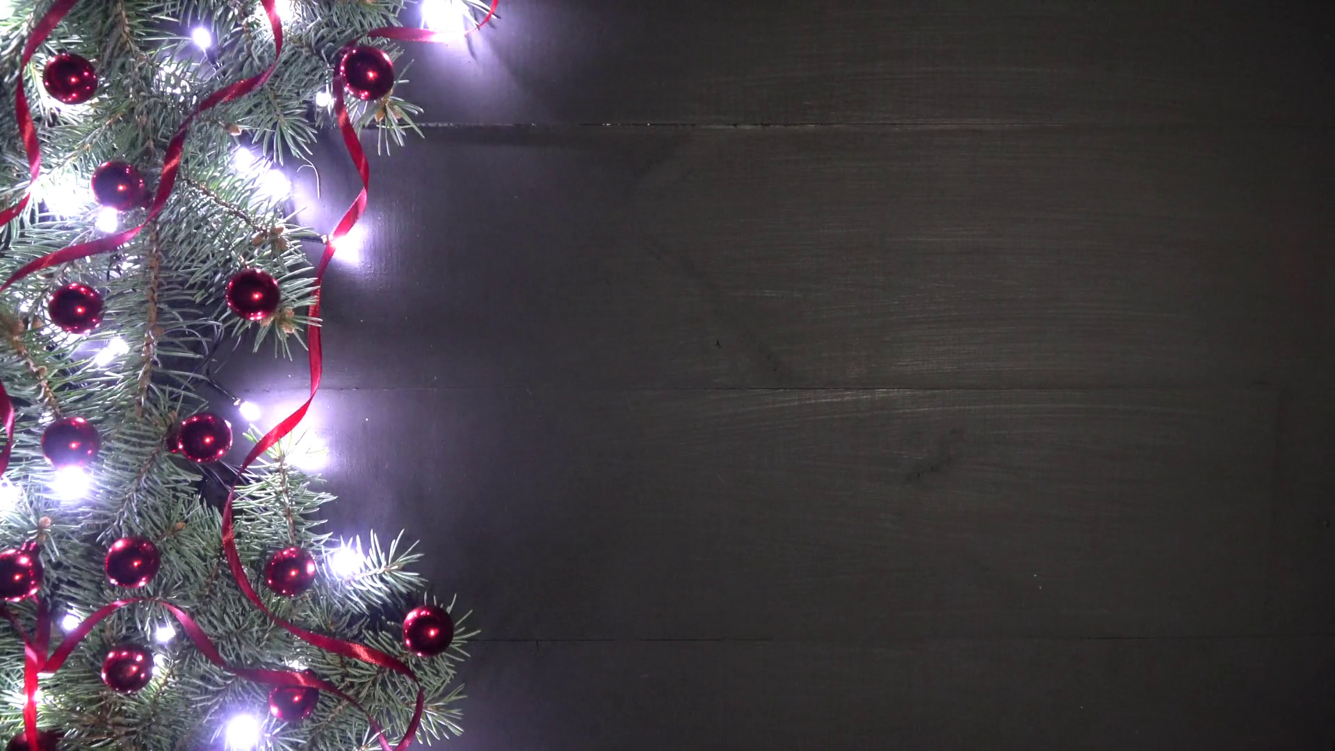 1920x1080 Xmas background of black wood decorated with fir branches, red baubles,  confetti and shimmering lights Stock Video Footage - Storyblocks Video