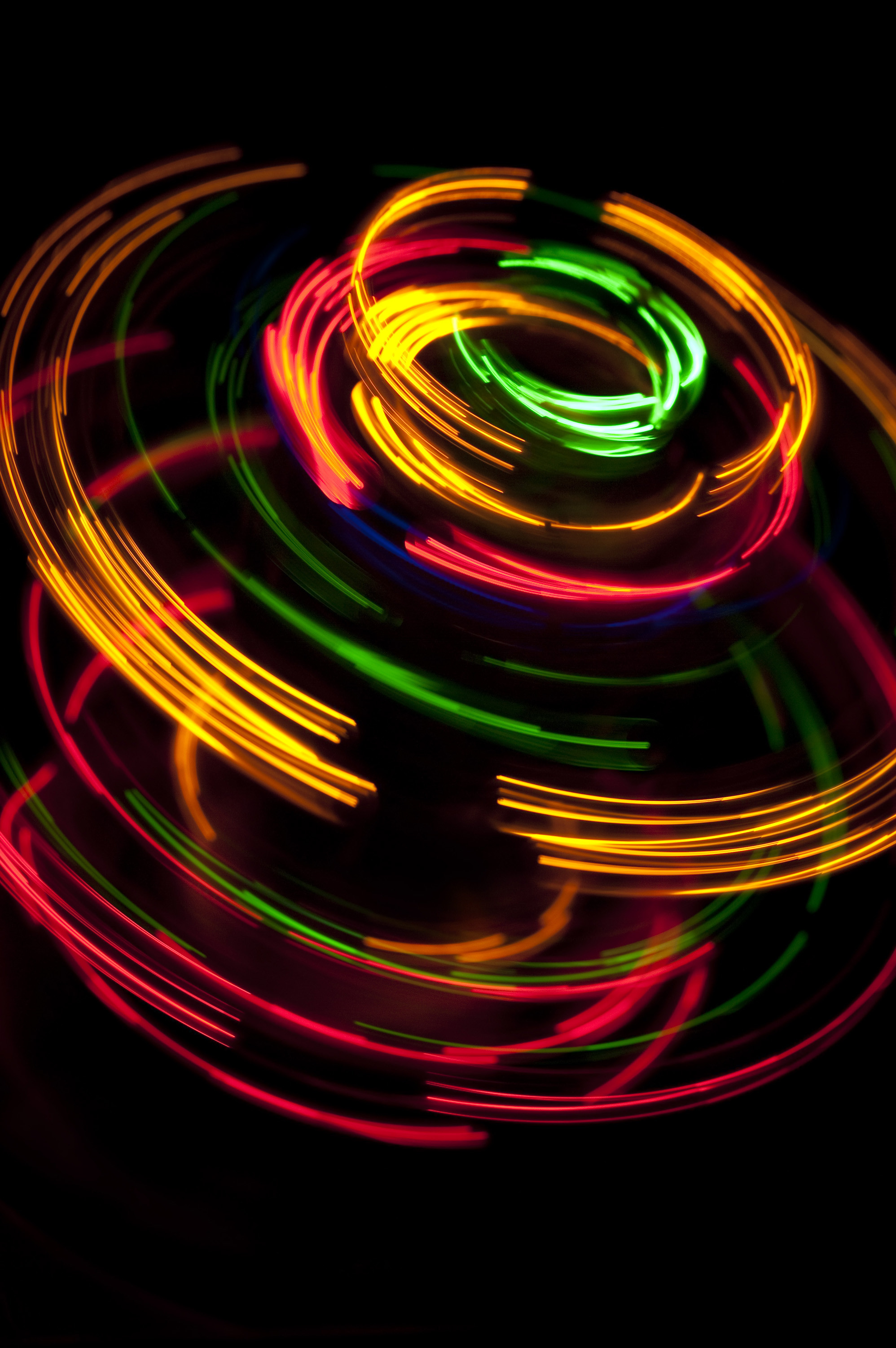 1996x3000 colorful series of overlapping curved lines of light glowing against a black  background