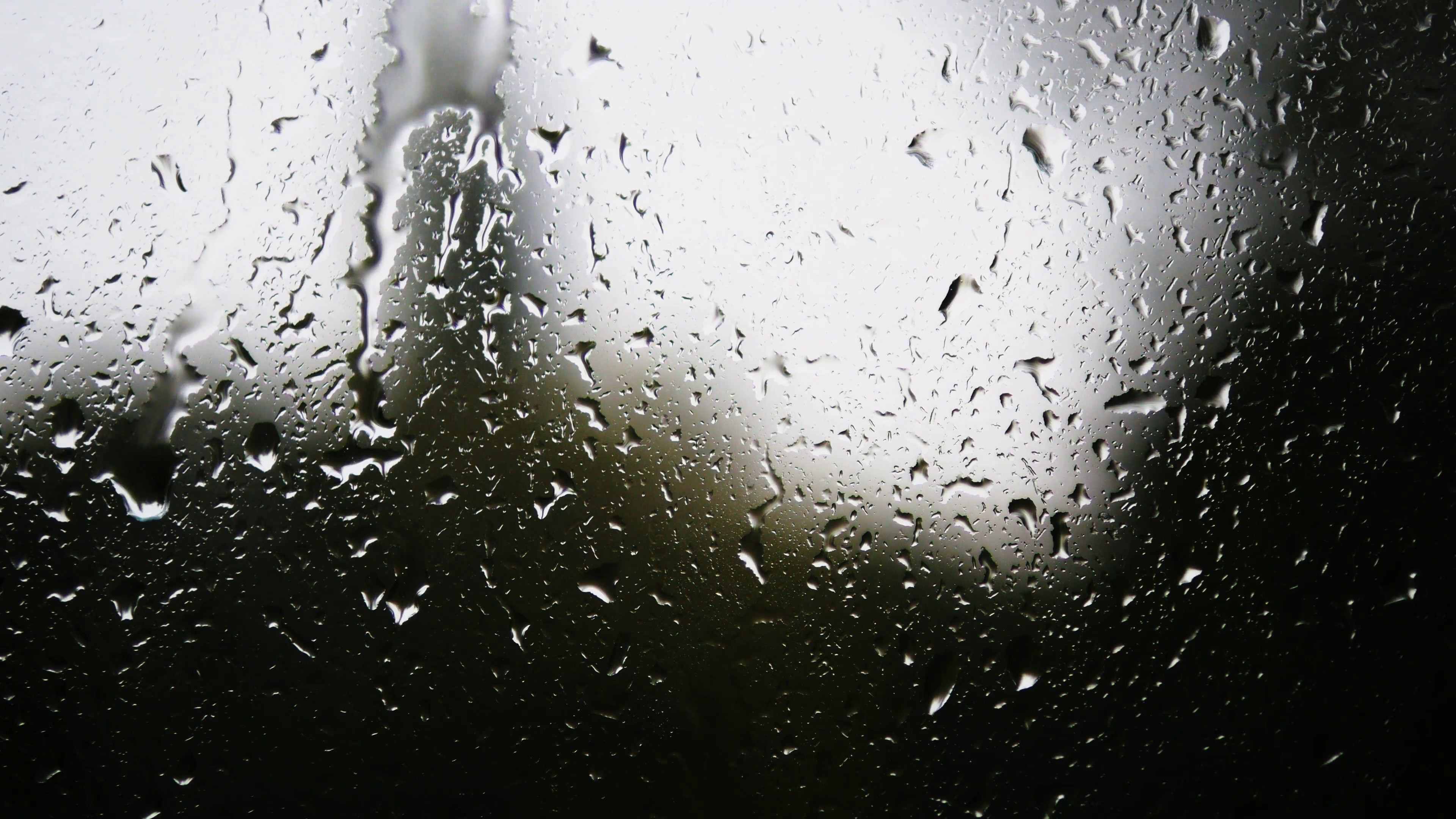 3840x2160 Rain drops on window glass with blur background. Blurred tree and sky.  Rainy days, rain running down window, bokeh Stock Video Footage -  VideoBlocks