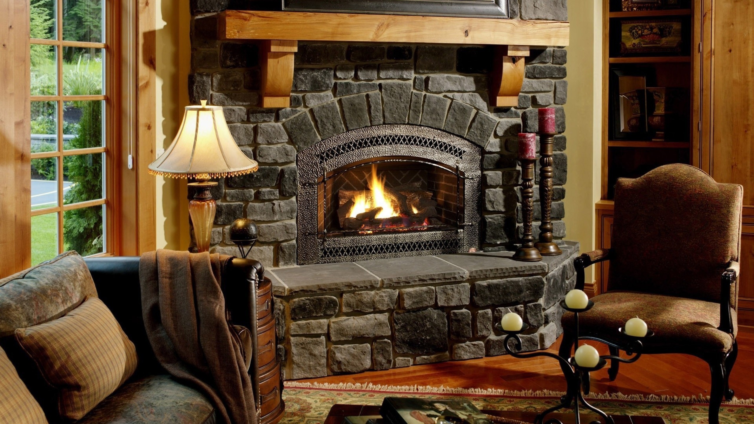 2560x1440  Wallpaper fireplace, chair, comfort, evening, cozy atmosphere