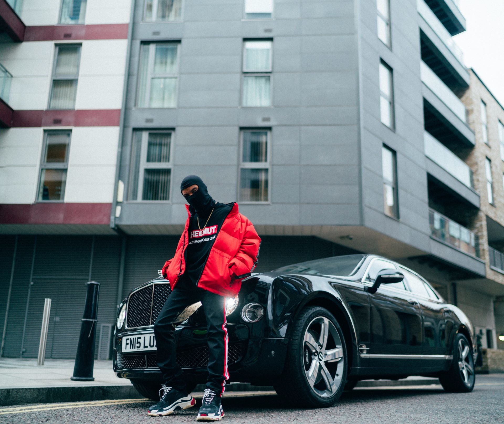 1920x1613 man in red jacket standing in front of black car wallpaper