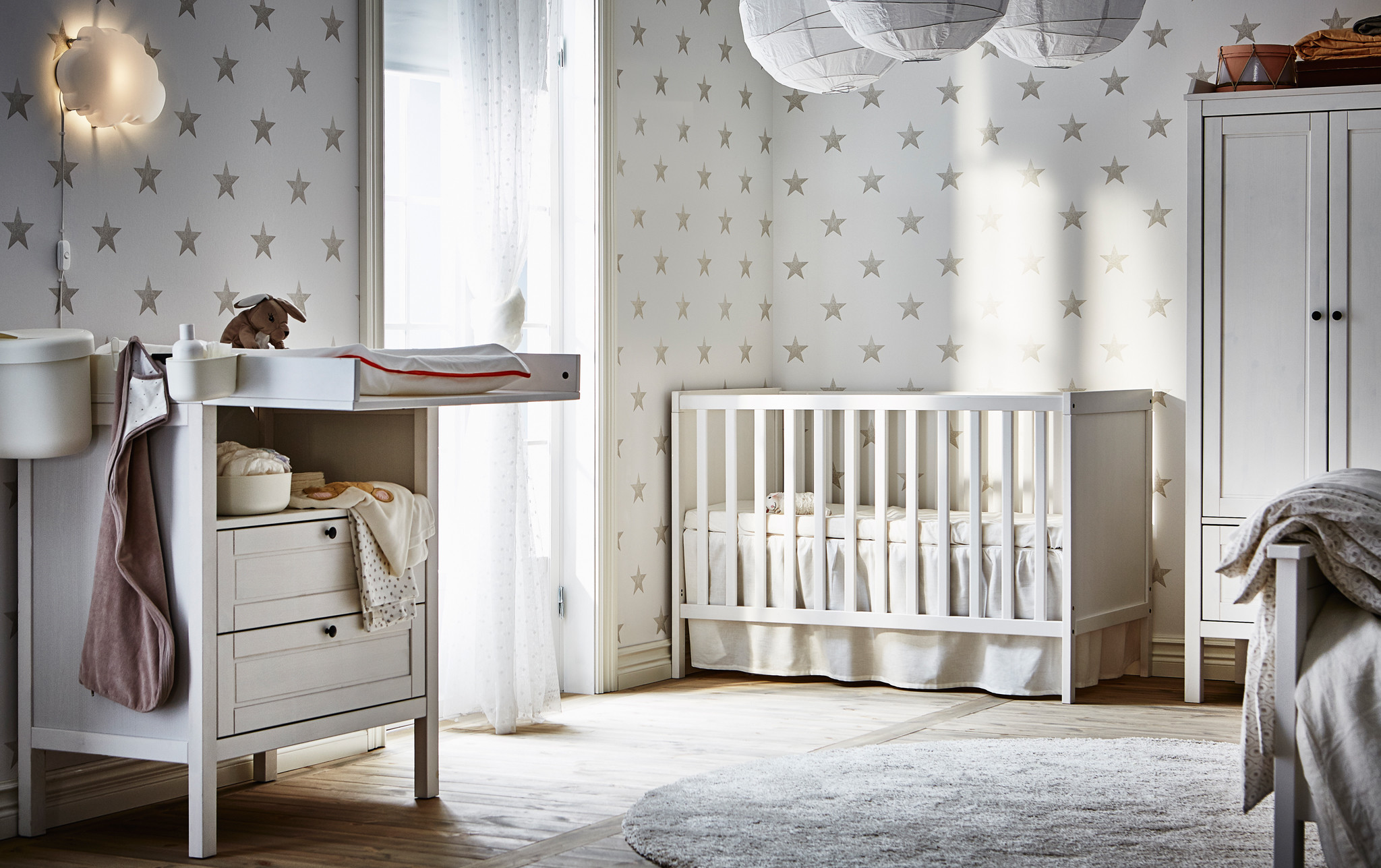 2048x1287 A changing table and cot in a grey and white nursery with star-patterned  wallpaper