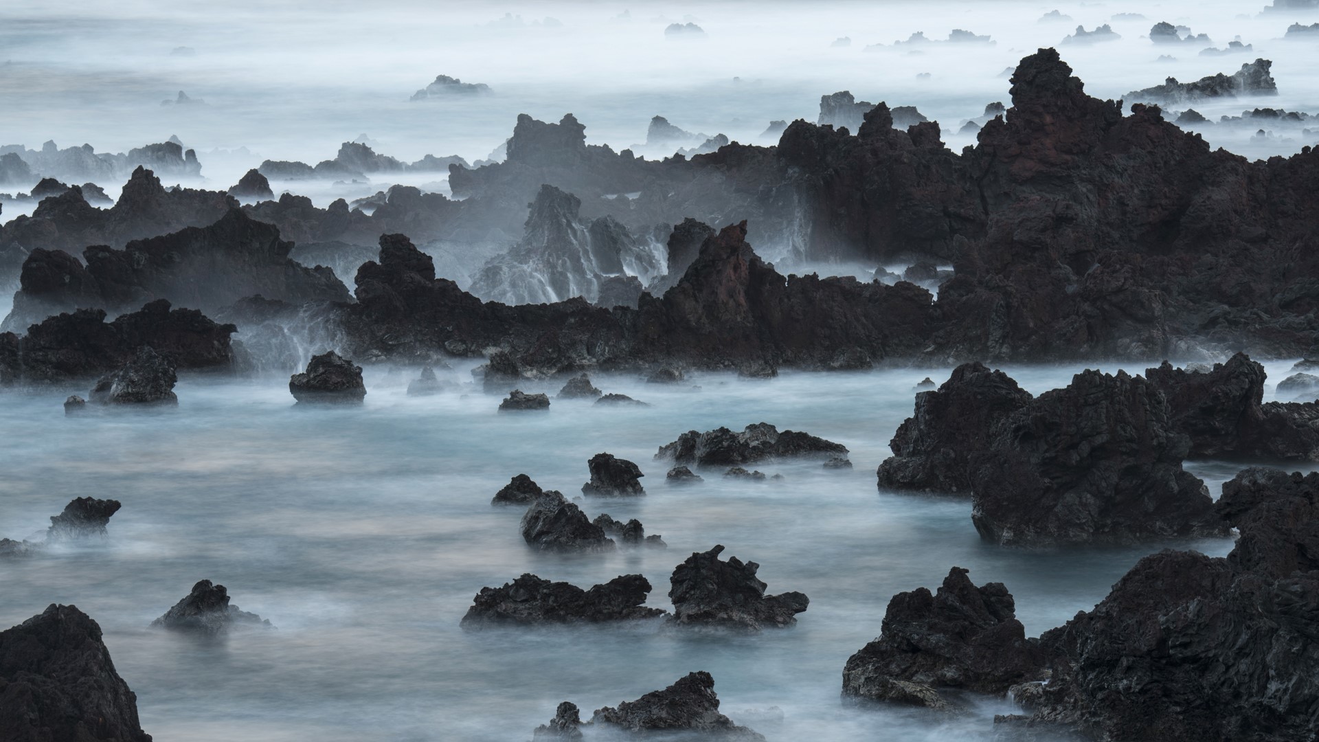 1920x1080 A long exposure of surf pouring over lava rocks at Easter Island, Chile
