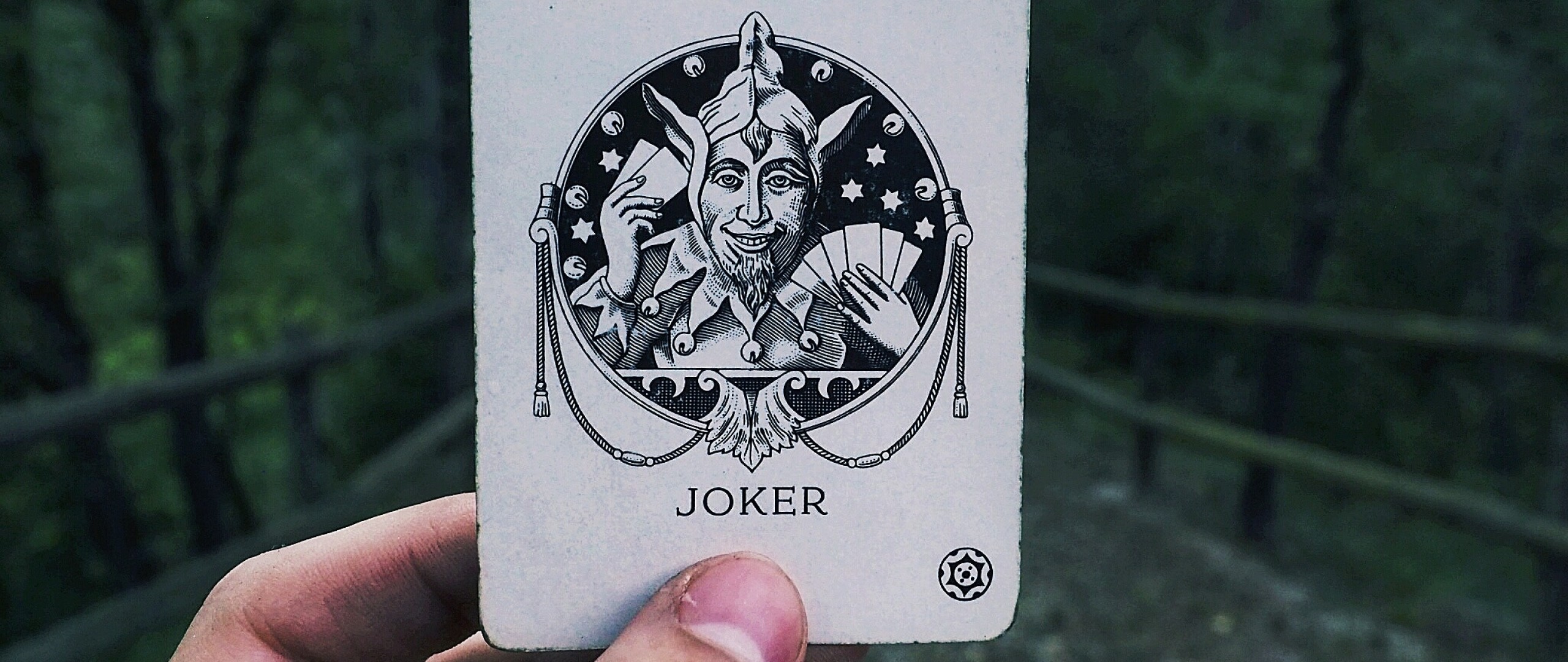 2560x1080  Wallpaper joker, card, hand