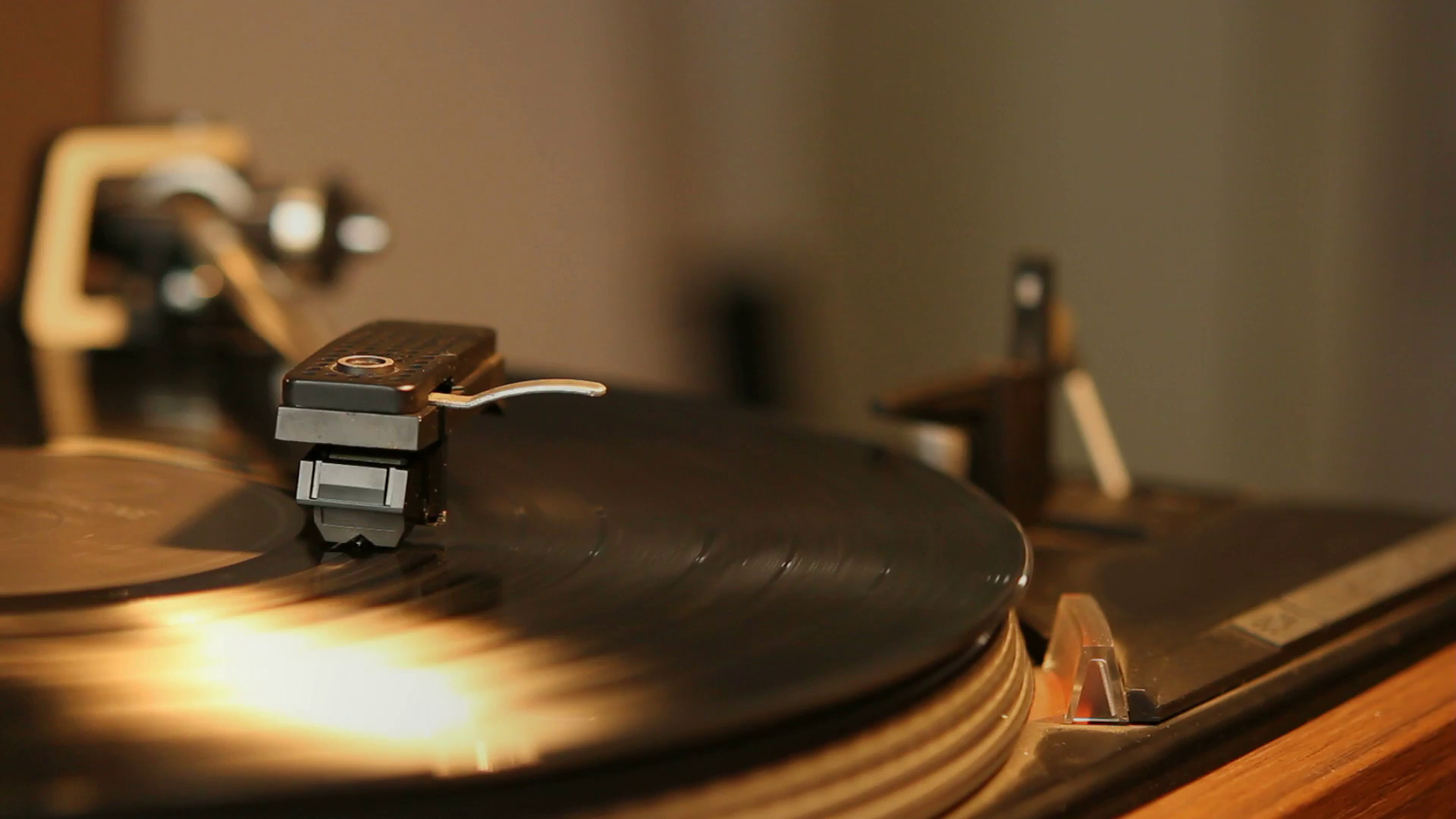 1920x1080 Close up HD movie of a record player playing a vinyl black record. The  needle is being put onto the record and removed again.