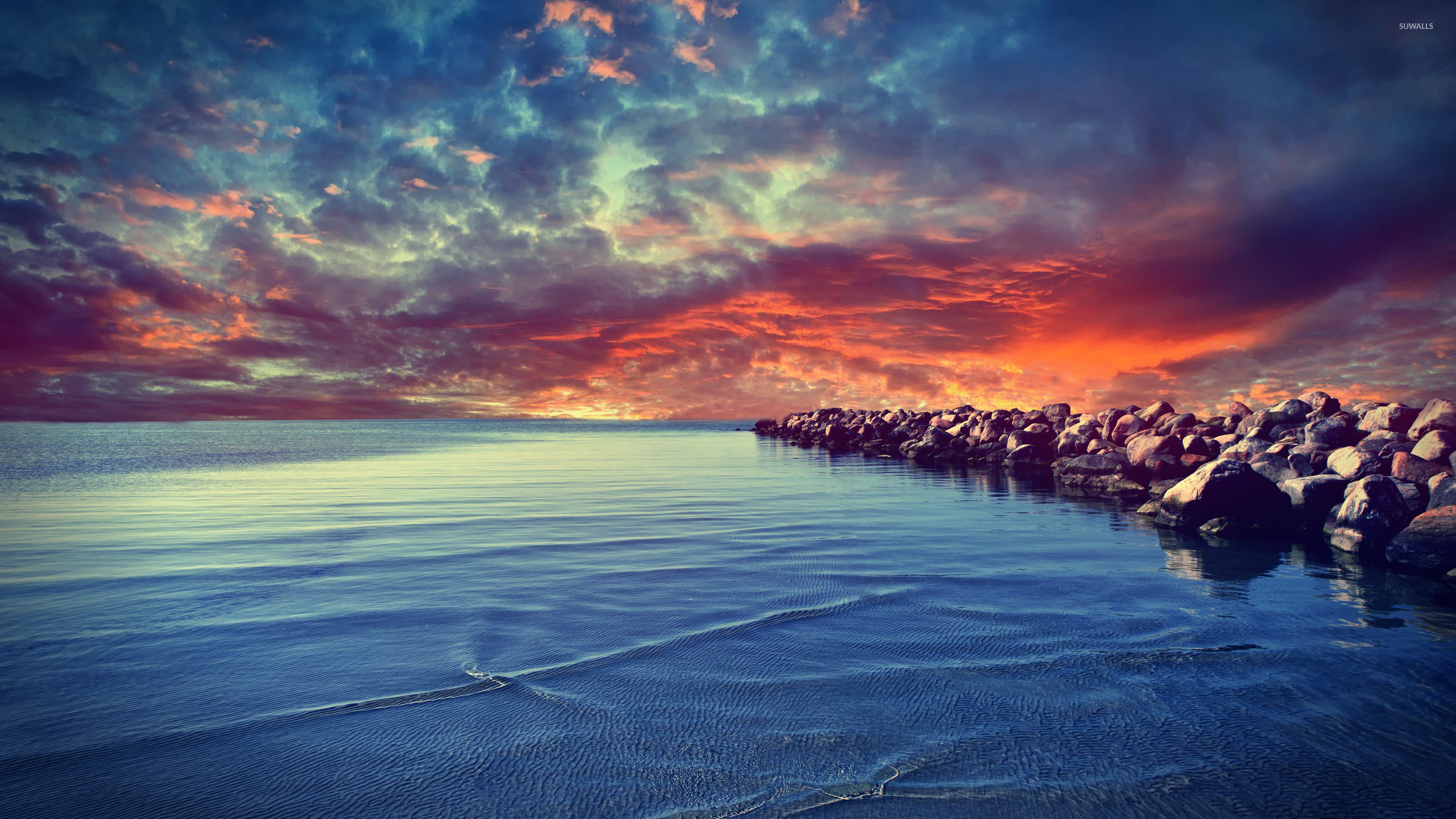 2560x1440 Sunset over the rocky beach wallpaper