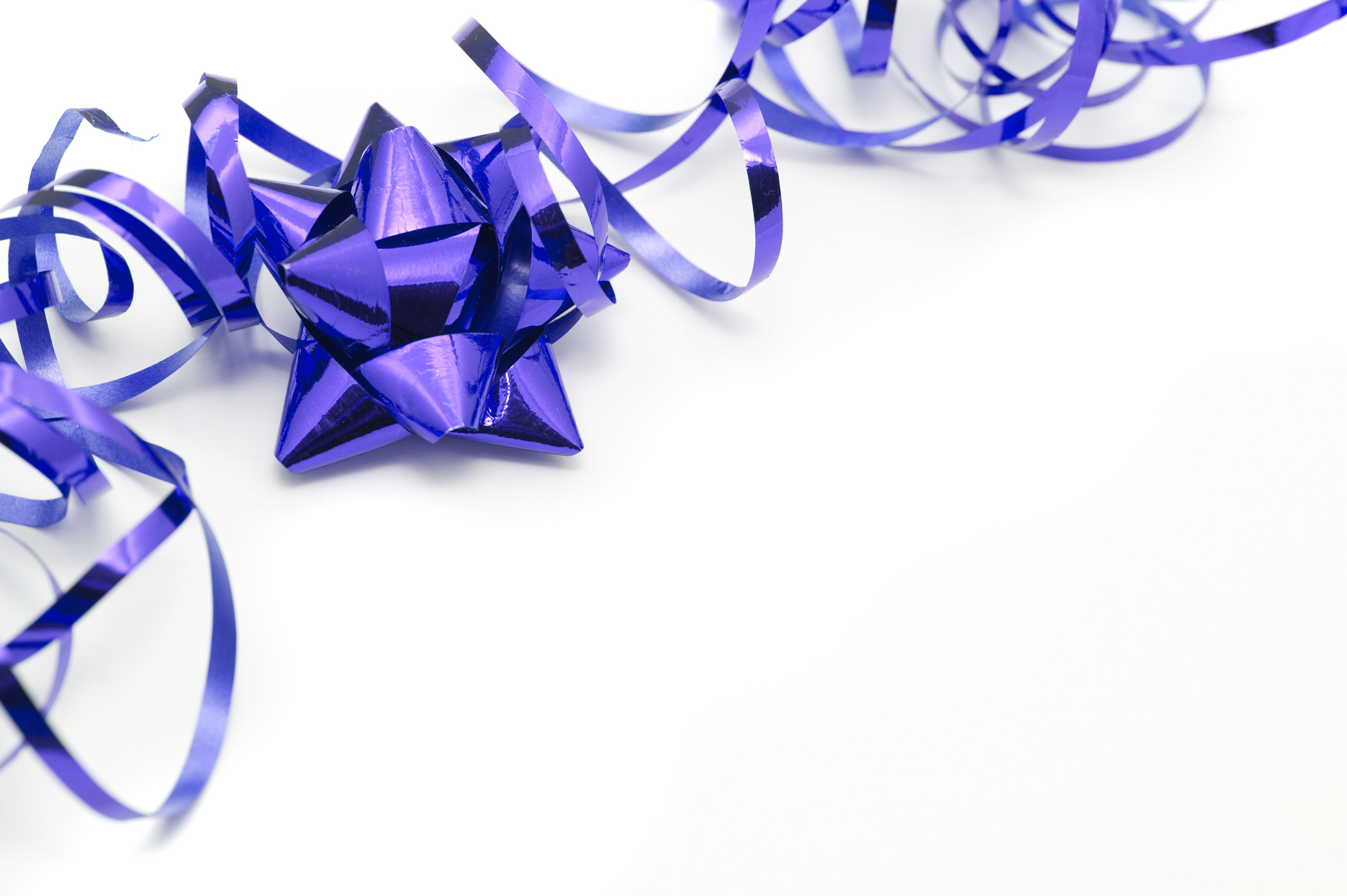 3000x1996 Purple festive corner border on a white background with copy space with a  twirled party ribbon