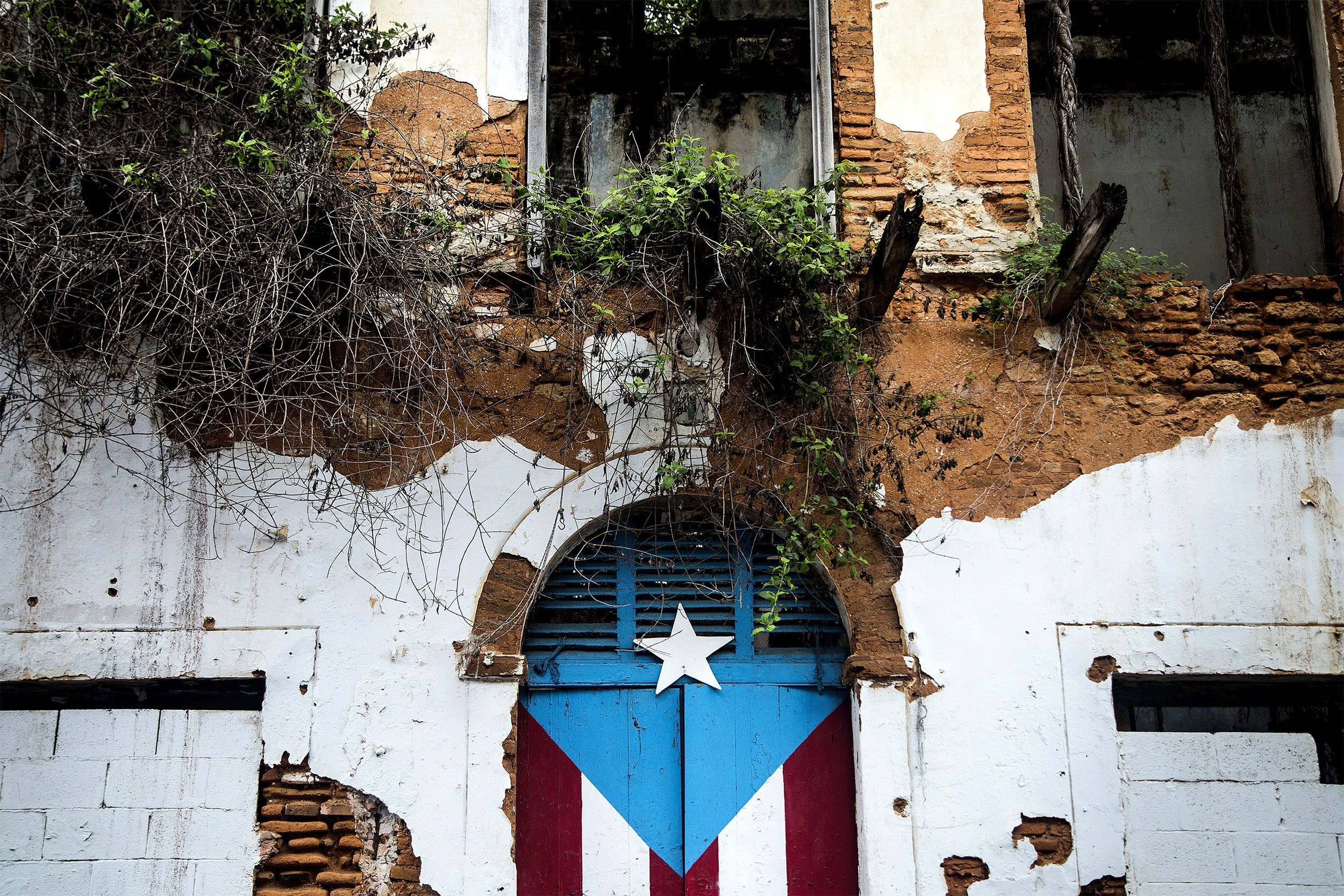 2500x1667 A Puerto Rican flag is painted on the doorway of an abandoned building in  San Juan