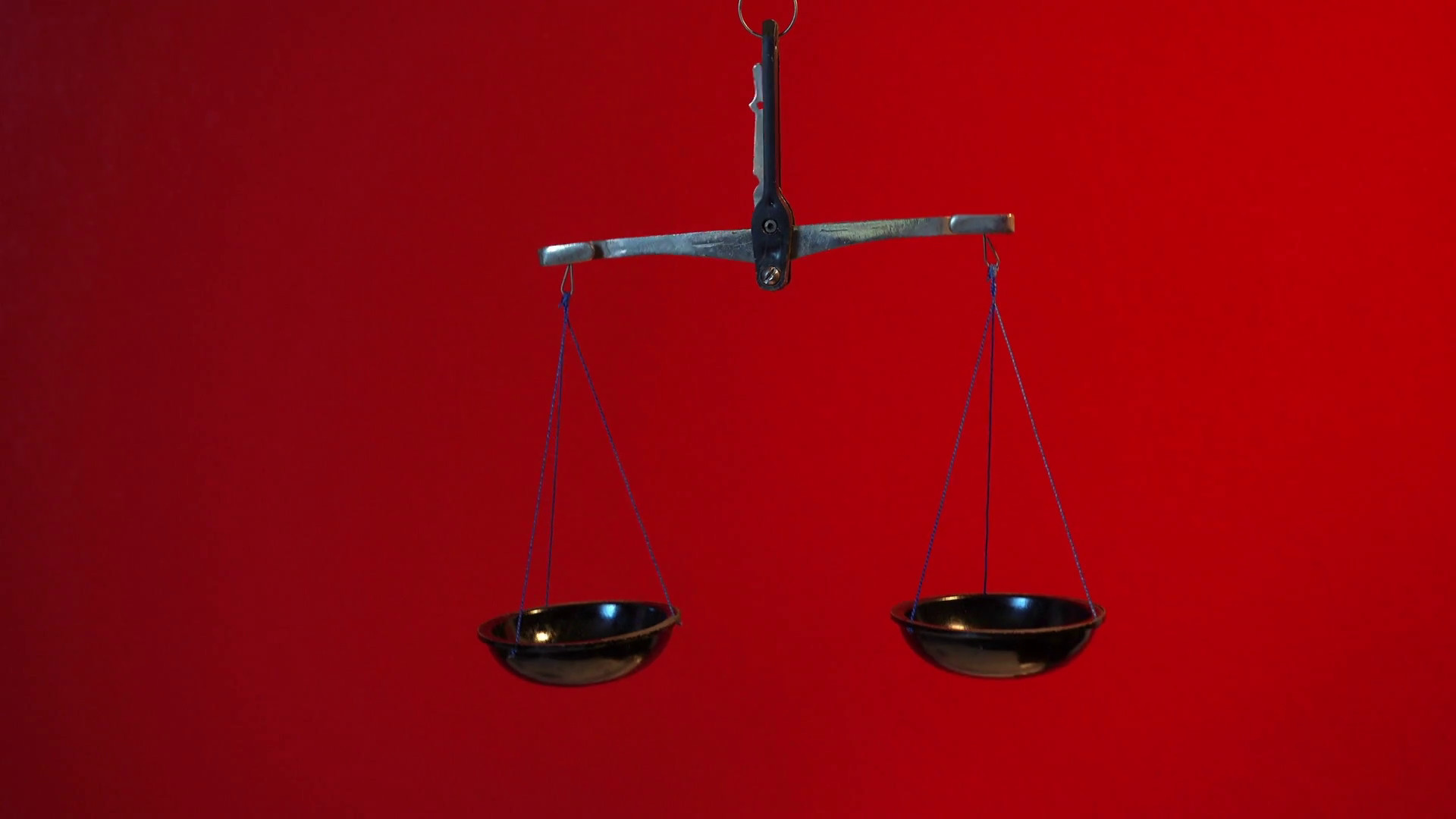 1920x1080 Vintage scales with a metal handle and black bowls.Scales evenly swinging  up and down. Scales on a red background. Symbol of justice.