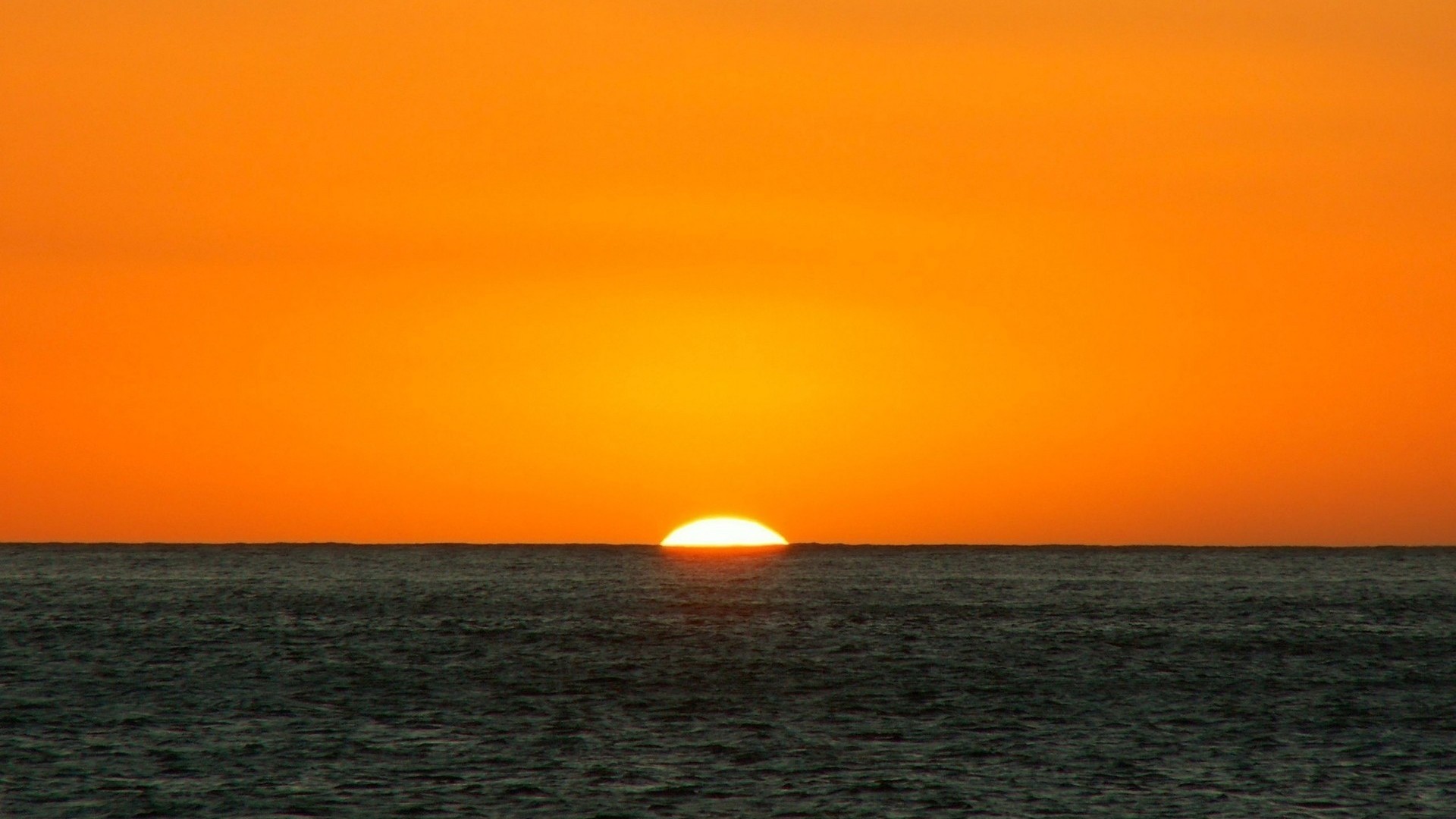 1920x1080  Wallpaper orange, dark blue, sea, horizon, sun