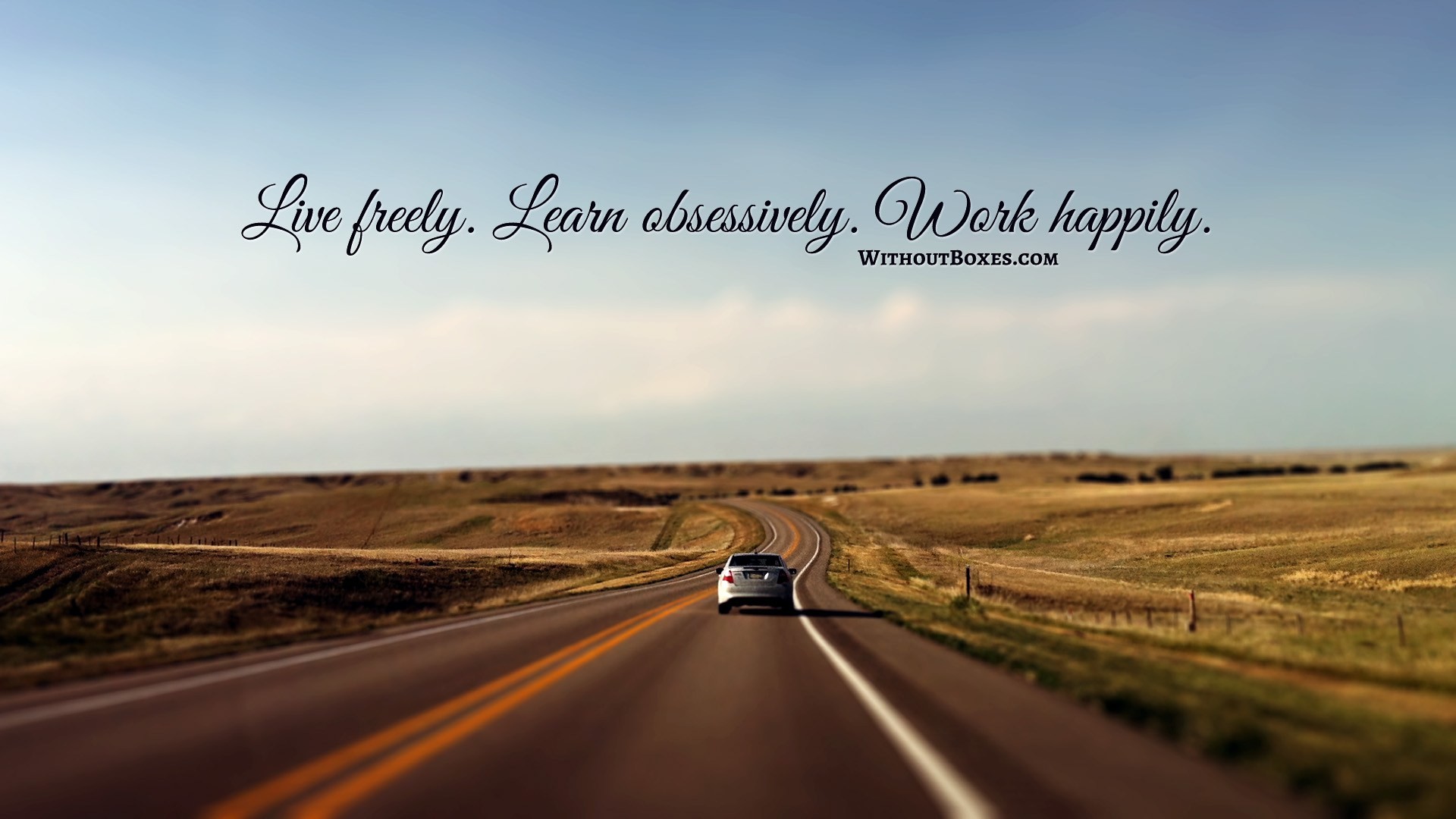 1920x1080 Wallpaper of car driving into the distance with the quote Live Freely,  Learn Obsessively,