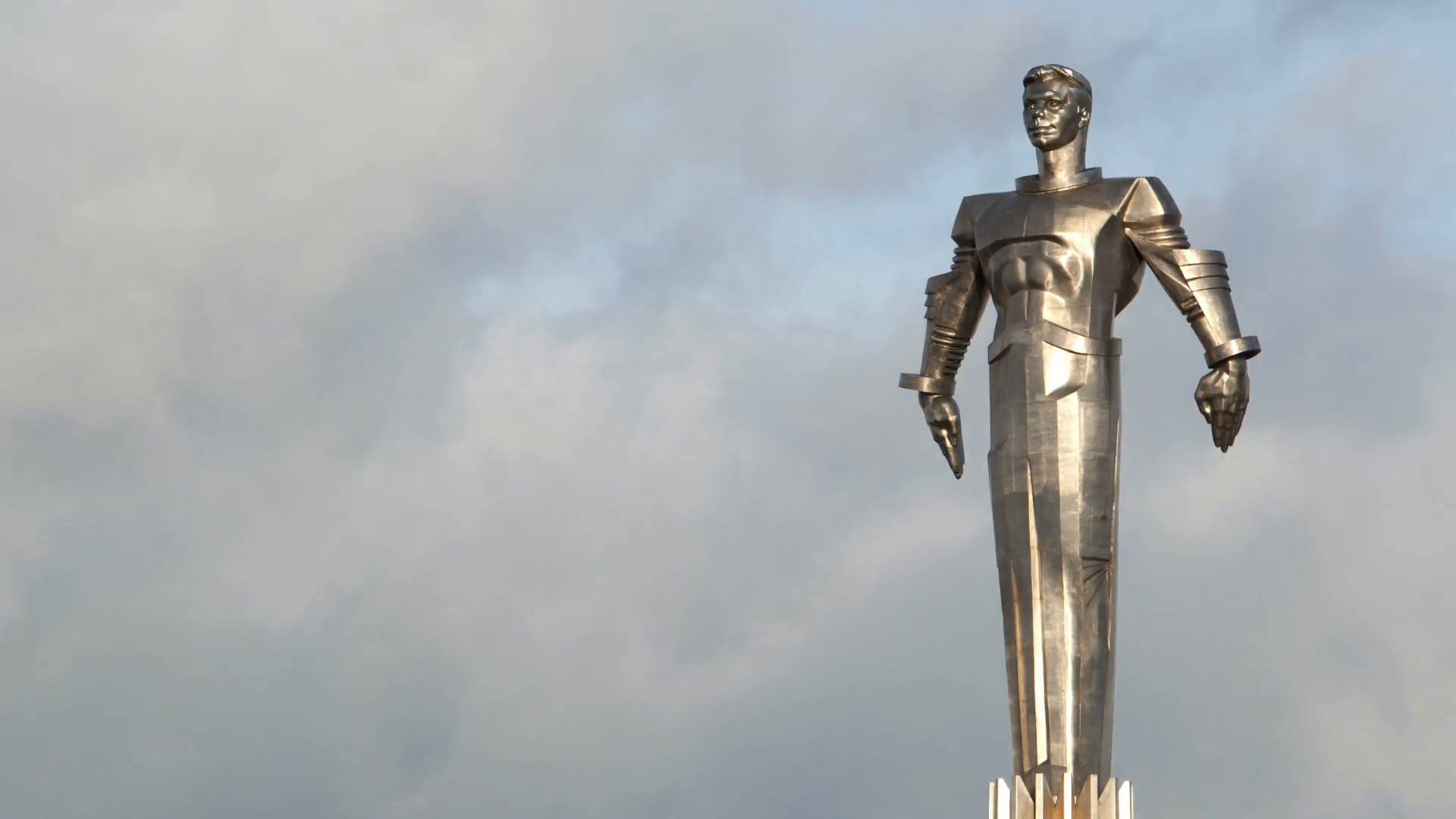1920x1080 Time lapse of clouds running behind monument to Yuri Gagarin. Metal statue  of famous Russian cosmonaut in Moscow. Wide shot.