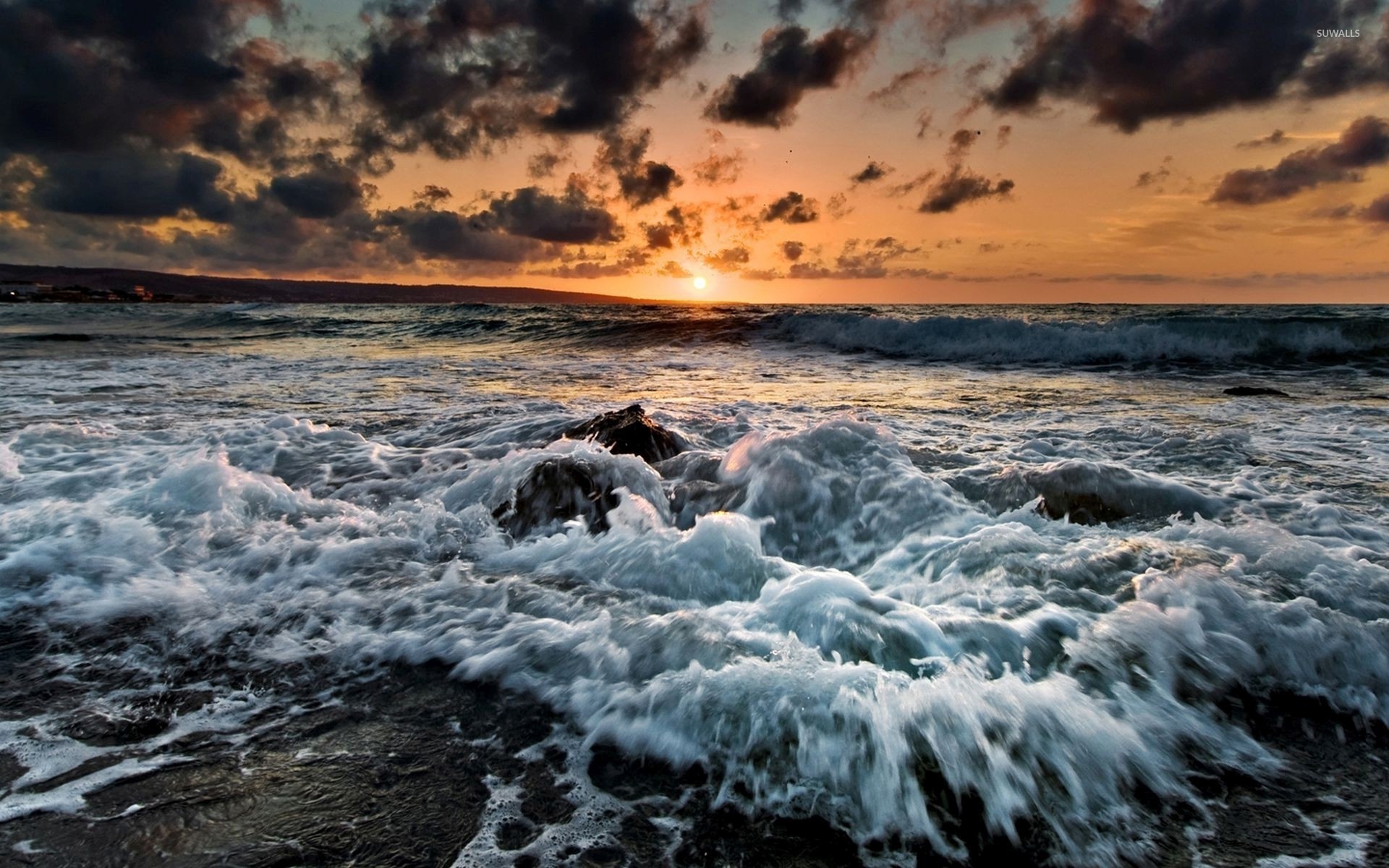 1920x1200 Waves reaching the rocky beach at sunset wallpaper