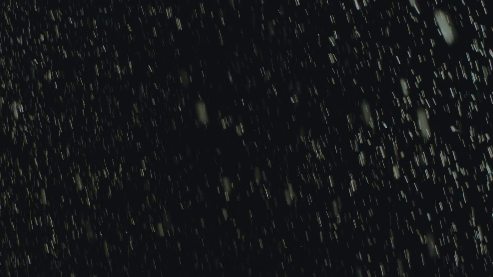 1920x1080 Rain drops falling on black, background, backlit,200fps,loopable.HD16:9  background of heavy hard rain falling in 200p slow motion conformed to 25p.