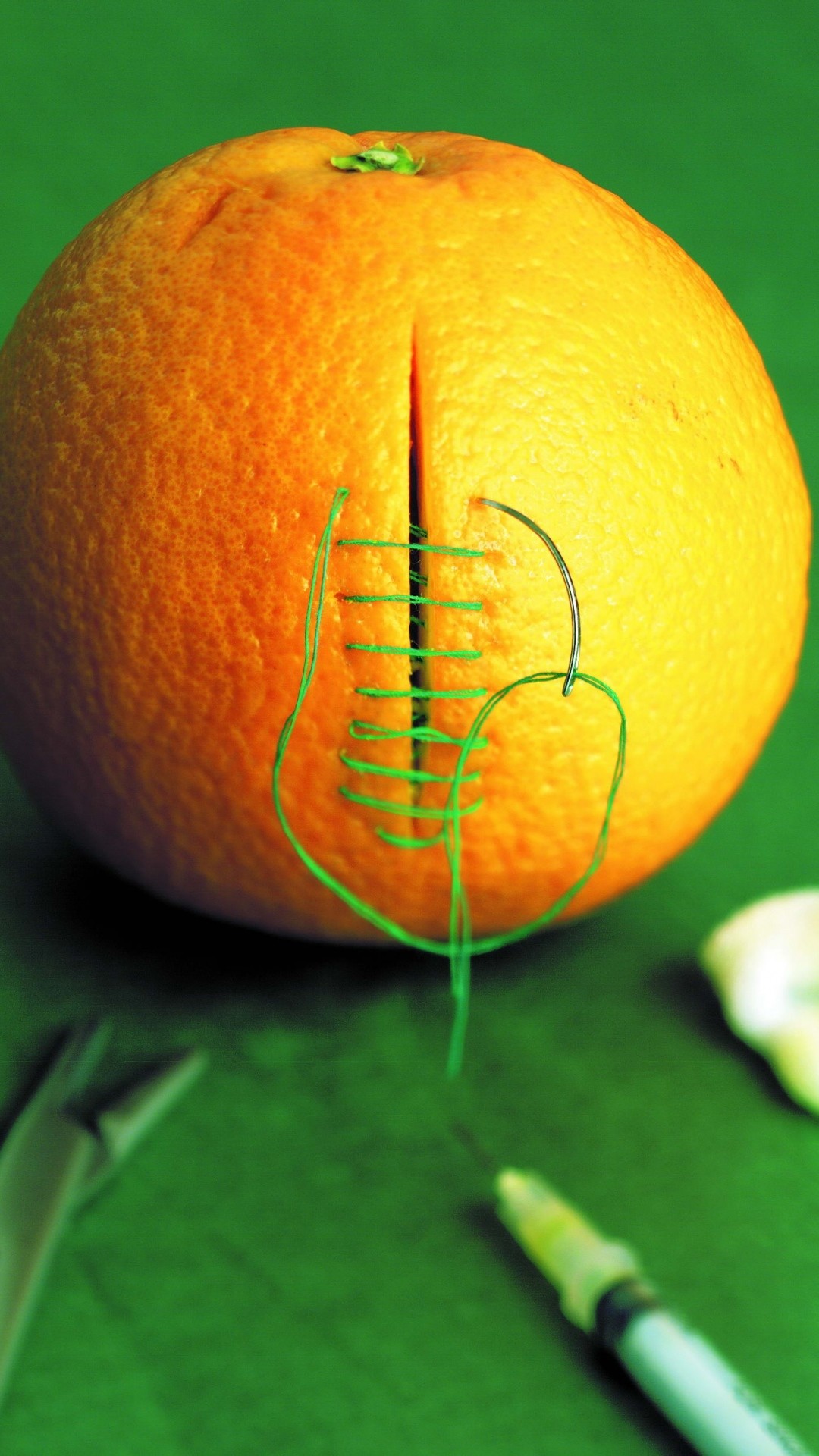 1080x1920  Wallpaper orange, cutting, sewing, stitching, green background
