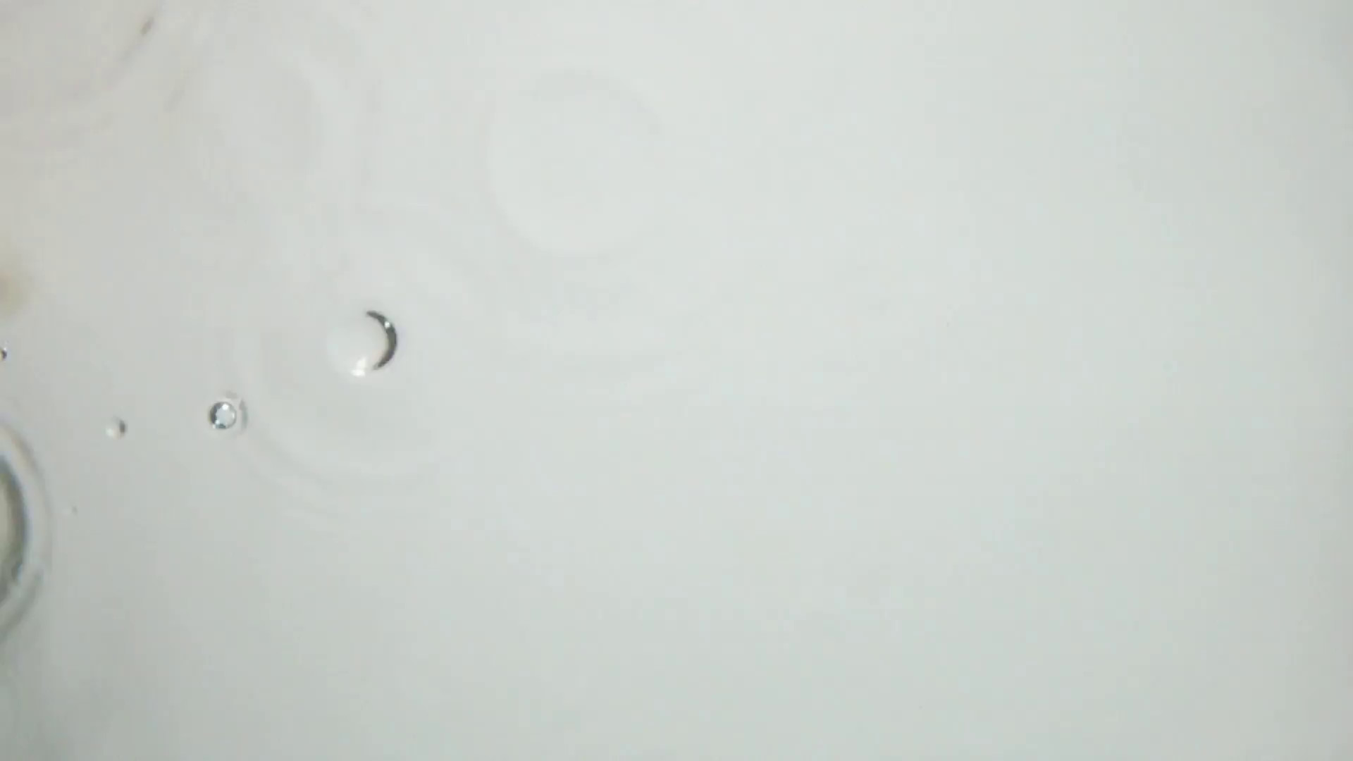 1920x1080 Little point droplet splashes at the transparent water surface with liquid  splashes. Super slow motion shot on white background isolated.