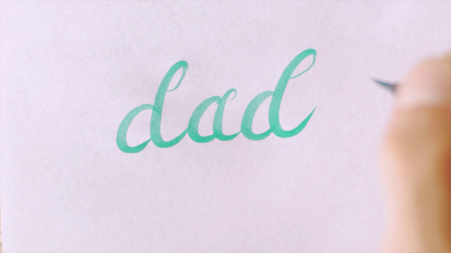 1920x1080 Hand writing the word DAD in cursive on white paper with a green brush pen  Stock Video Footage - Storyblocks Video