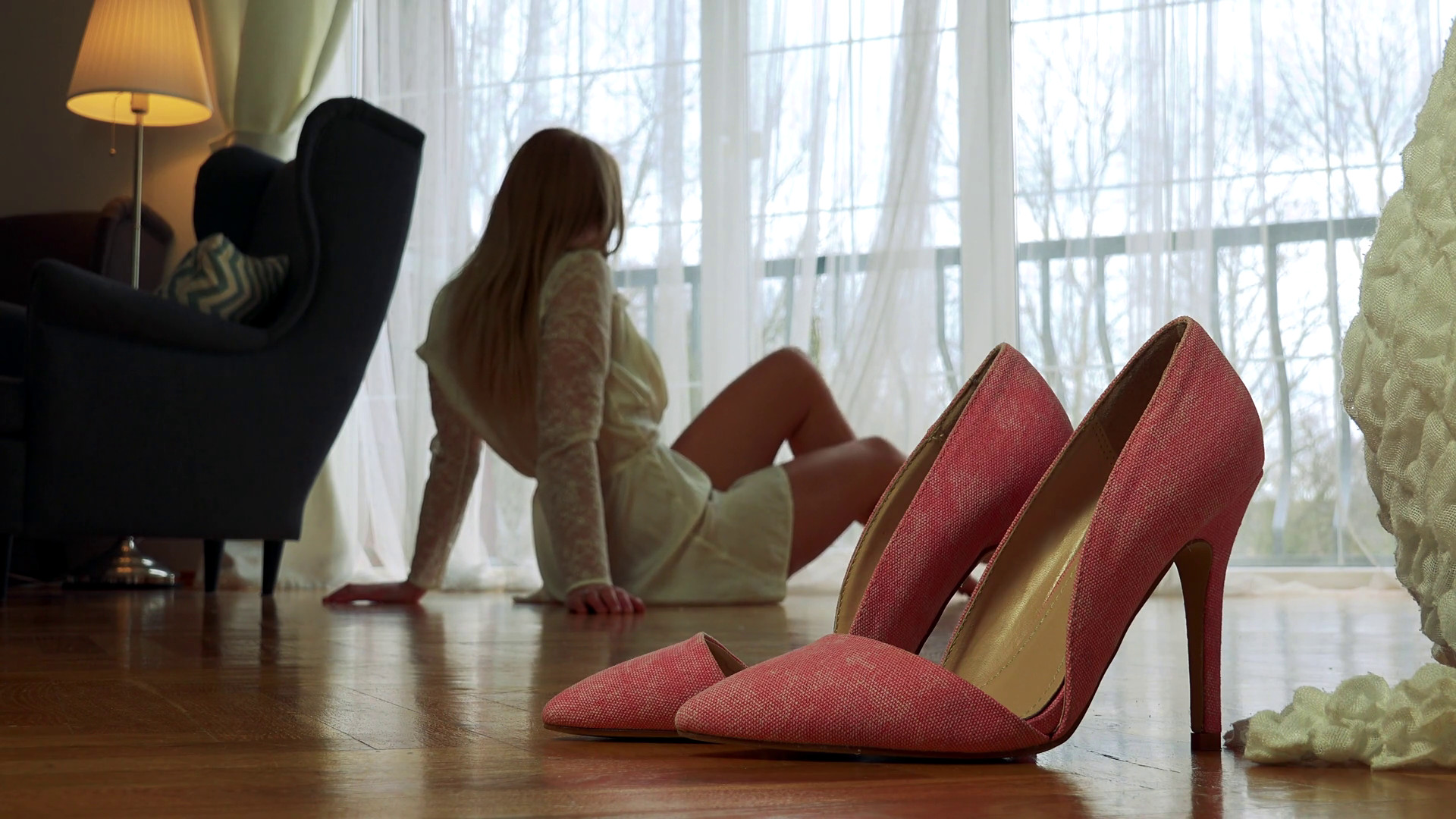 1920x1080 A closeup on a pair of pink high heel shoes on a wooden floor in the middle  of a room, a blonde woman sits in the blurry background and makes poses  Stock ...