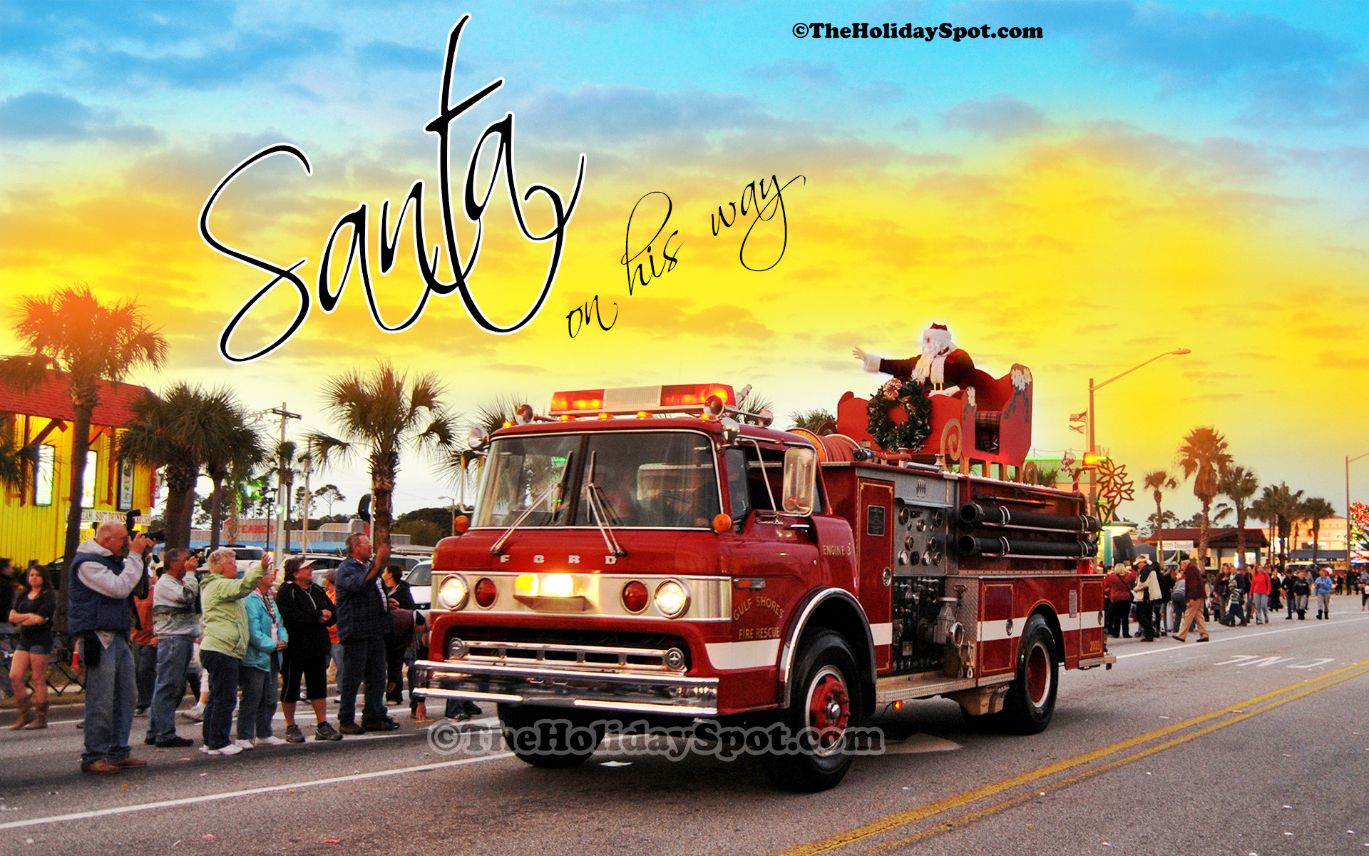 1920x1200 Christmas wallpaper of Santa coming to town on a firefighter truck.